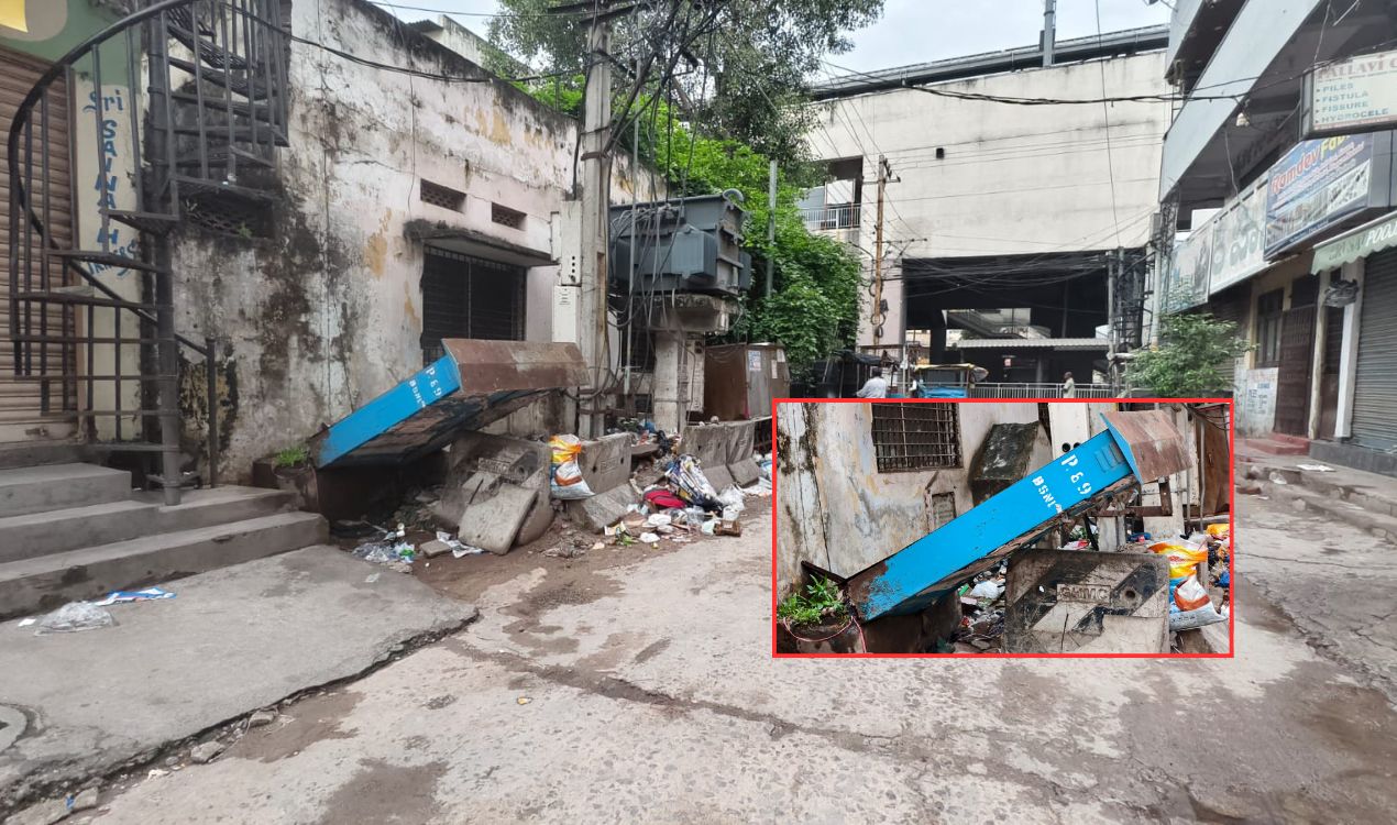 LB Nagar ward office street with fallen BSNL box and dumped garbage near metro station